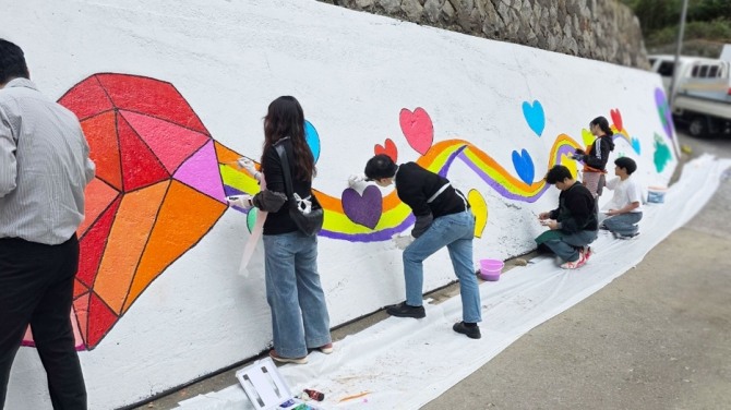 키움과나눔 회원들이 지난해 10월 서울 동작구 본동에서 청소년 안심로드(Road) 벽화 그리기 봉사 활동을 실시하고 있다. 사진 키움증권