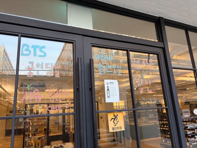 광화문 인근 와인 매장 유리창에 BTS 컴백 공연 관련 이벤트 안내 문구가 적혀 있다. 사진=이지현 기자