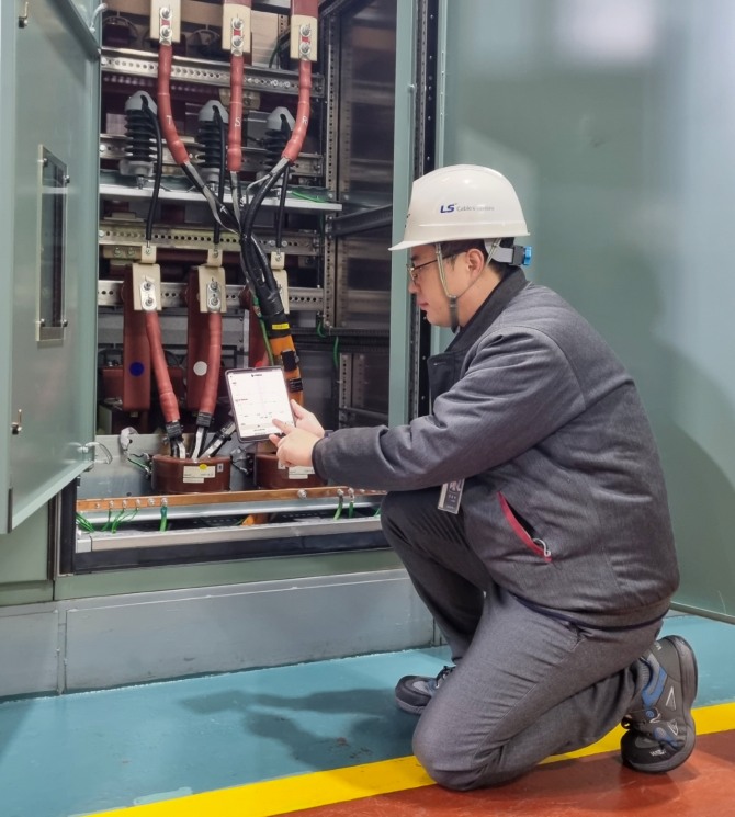 LS전선 작업자가 모바일 기기에 설치된 아이체크 시스템 애플리케이션을 통해 배전 케이블의 상태를 실시간으로 모니터링 하고 있다. 사진=LS그룹