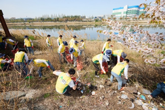 지난 18일 인천 미추홀구 용현갯골유수지에서 신천지자원봉사단 인천지역연합회 봉사자들이 쓰레기를 치우는 있다.  사진=신천지자원봉사단 인천지역연합회