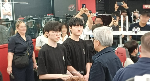 젠슨 황 대표가 페이커 선수(왼쪽)와 만나 악수를 나누며 이야기를 주고 받고 있다. 가운데는 팀 동료 '페이즈' 김수환 선수. 사진=이원용 기자