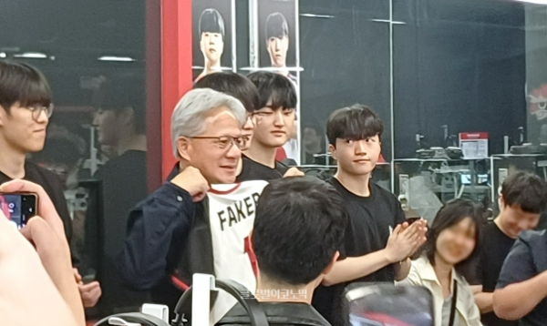 페이커 선수의 유니폼을 든 채 기념 촬영을 하는 젠슨 황 대표. 사진=이원용 기자