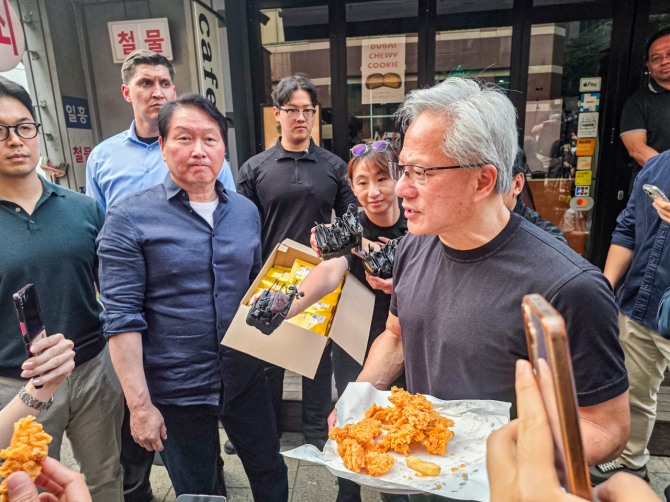 최태원 SK그룹 회장(사진왼쪽)과 젠슨 황 엔비디아 최고경영자(CEO)가 7일 오후 서울 강남구 깐부치킨 삼성점 앞에서 취재진과 시민들에게 치킨을 나눠주며 대화하고 있다. 사진=공동취재단