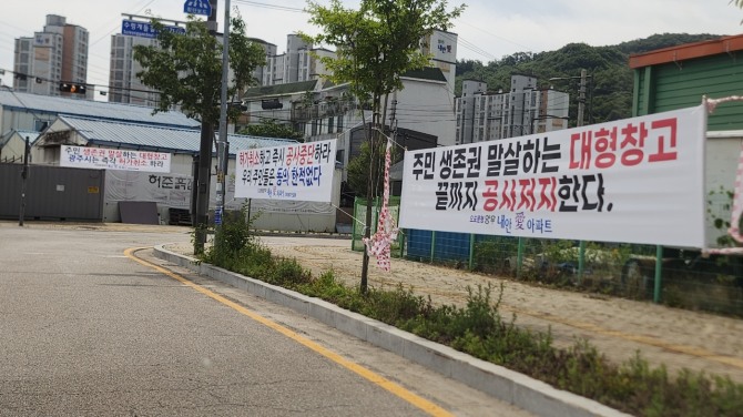 오포문형양우내안애 아파트 진입로에 물류창고 공사 중단 현수막이 걸려있다. 사진=이지은 기자