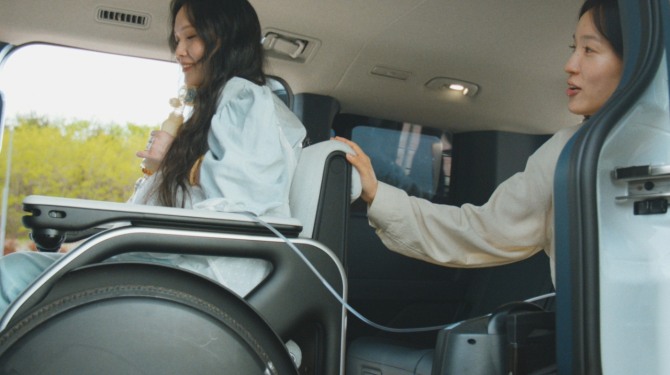 김온유 씨(왼쪽)가 기아 PV5 WAV 실내에서 V2L(Vehicle to Load) 기능을 활용하며 가족과 함께 이동하고 있다. 사진=현대자동차그룹