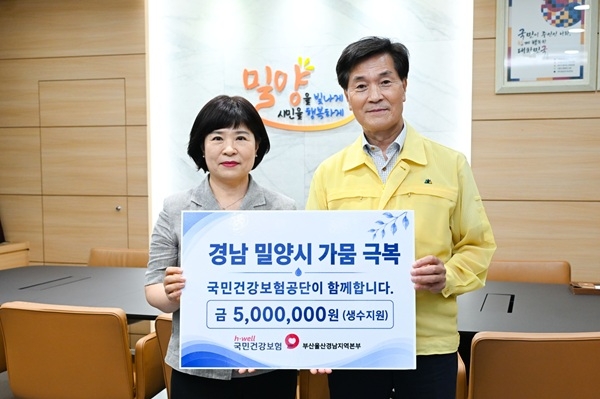 강효정 국민건강보험공단 밀양창녕지사장(왼쪽)이 13일 안병구 밀양시장에게 식수지원 성금을 전달했다. 사진=건보공단 부울경지역본부 