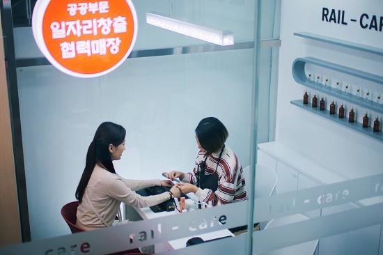 부산역에 마련된 장애인 네일케어 매장 ‘섬섬옥수’에서 여성 장애인 근로자가 이용객에게 서비스를 제공하고 있다. 철도역 공간을 장애인 전문 일자리로 연결한 사례다. 사진=에스알·뉴시스