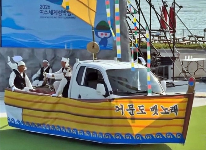 지난 15일 2026여수세계섬박람회장에서 거문도뱃노래 공연단이 흰색 화물차를 배처럼 꾸며 공연하고 있다. 이 장면이 공개된 뒤 박람회 콘텐츠 수준을 둘러싼 논란이 일었다. 사진=유튜브 갈무리