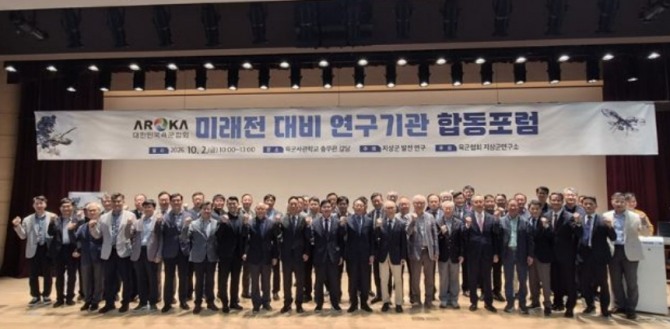 2일 육군사관학교 충무관 강당에서 열린 '미래전 대비 연구기관 합동포럼'에서 엄기학 육군협회장(가운데)이 참석자들과 기념사진 촬영을 위해 구호를 외치고 있다. 사진=육군협회