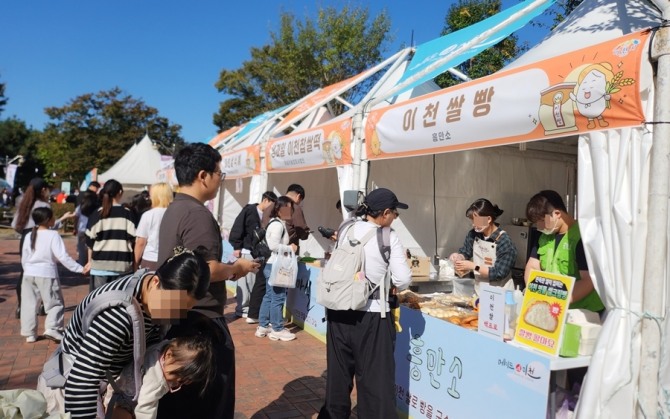14일 이천 복하천 수변공원에서 개막한 '제25회 이천쌀문화축제' 먹거리 부스에 방문객들이 줄지어 있다. 사진=이지은 기자