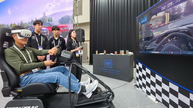 '2026 대한민국 미래모빌리티엑스포' GM 부스의 버추얼 모빌리티 존에서 관람객이 VR 기기와 운전 시뮬레이터를 활용해 가상주행을 체험하고 있다. 사진=GM