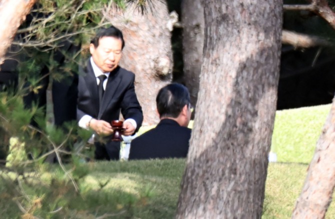 23일 이재용 삼성전자 회장이 경기도 수원 선영에서 열린 고 이건희 삼성그룹 회장 6주기 추도식에 참석해 술잔을 건네받고 있다.