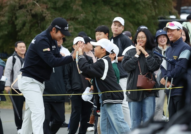 장유빈이 이동중에 주니어 갤러리와 하이파이브를 하고 있다. 사진=KPGA 민수용 포토